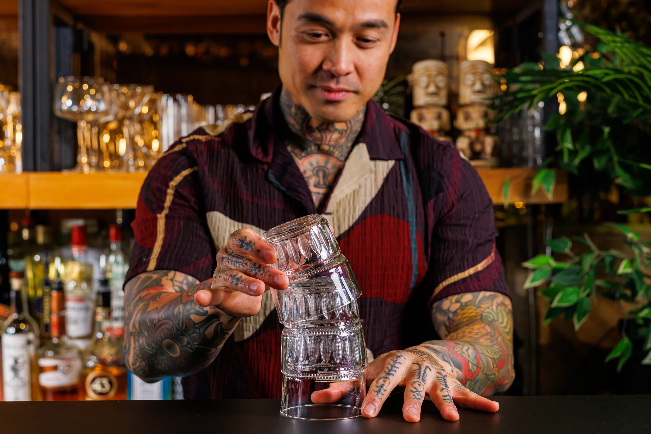 Bartender stacking "New Era" by ONIS tumblers at a bar